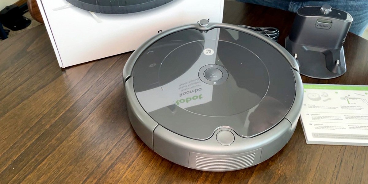 Robot vacuum on floor next to product packaging