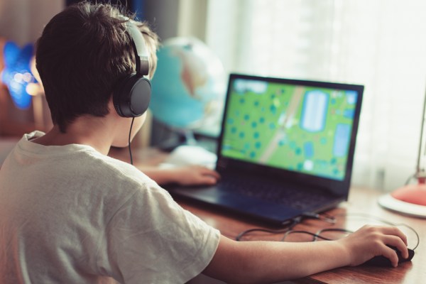 Person sitting at desk playing a game on laptop