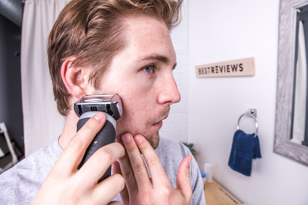 Person shaving with electric razor
