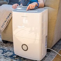 Person touching button on dehumidifier