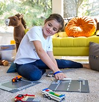 a young girl playing Lego